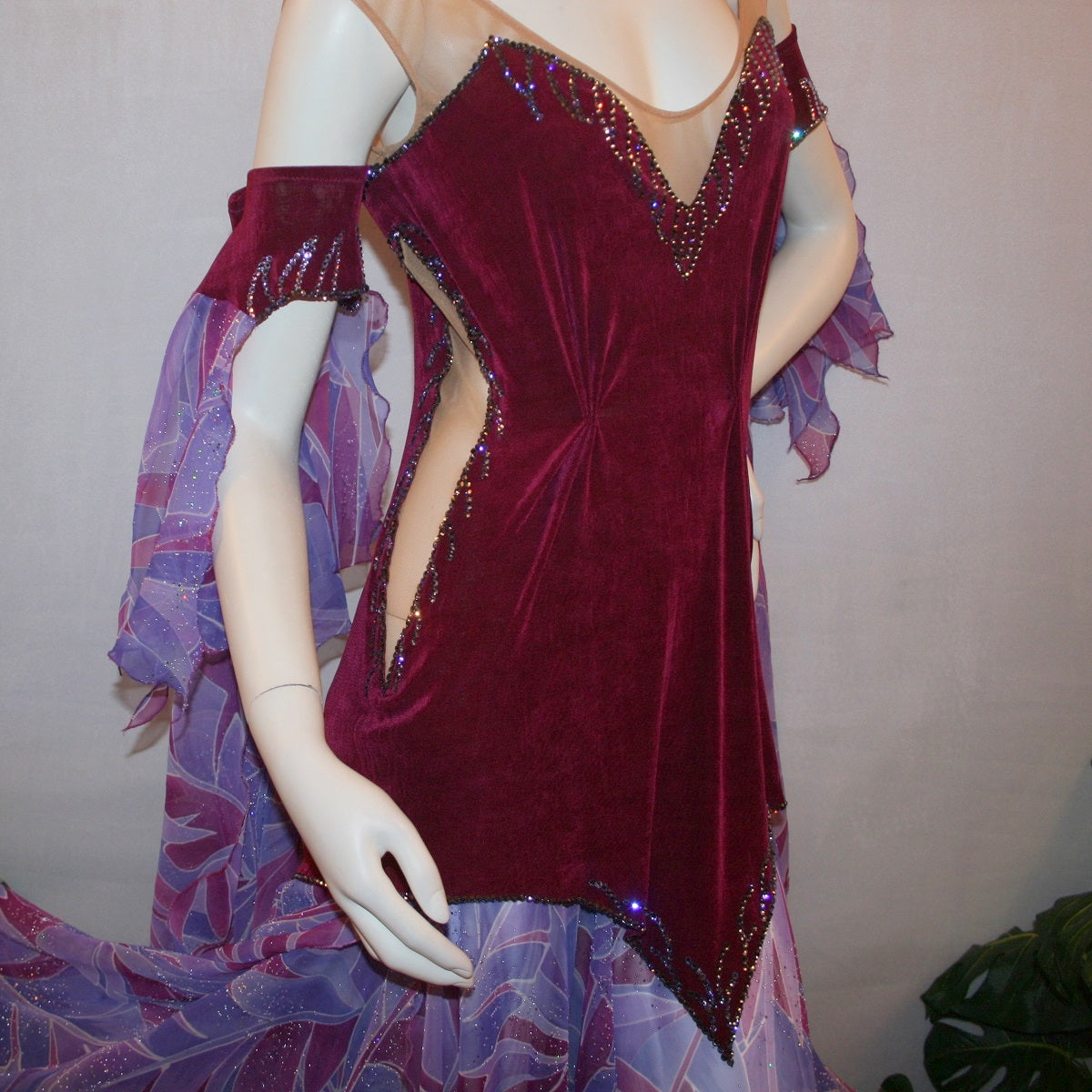 Crystal's Creations close up view of top of Magenta converta ballroom dress created of magenta solid slinky on a nude illusion base with tropical chiffon print skirtings of magenta & orchids, is embellished with tanzanite & orchid rhinestone work.