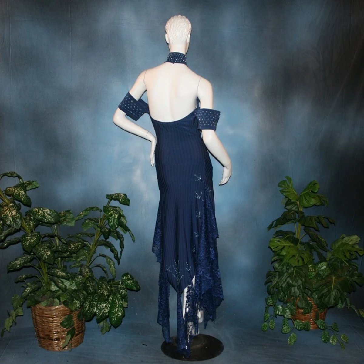 back view of Navy blue tango dress or Latin/rhythm dress created in rib textured lycra, with flounces of barcelona lace, adorned with light sapphire Swarovski rhinestones & larger navy lucite gems.