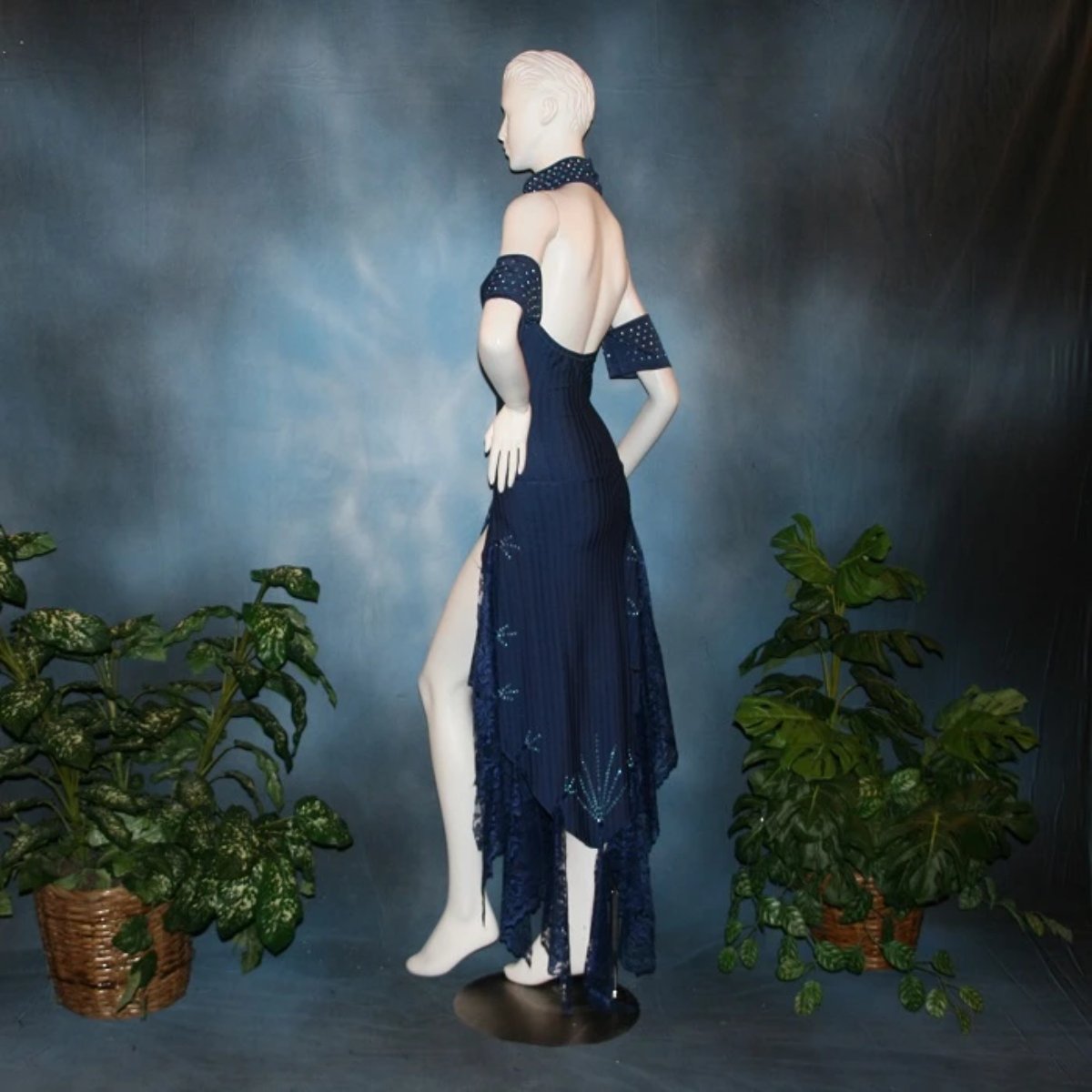 side view of Navy blue tango dress or Latin/rhythm dress created in rib textured lycra, with flounces of barcelona lace, adorned with light sapphire Swarovski rhinestones & larger navy lucite gems.