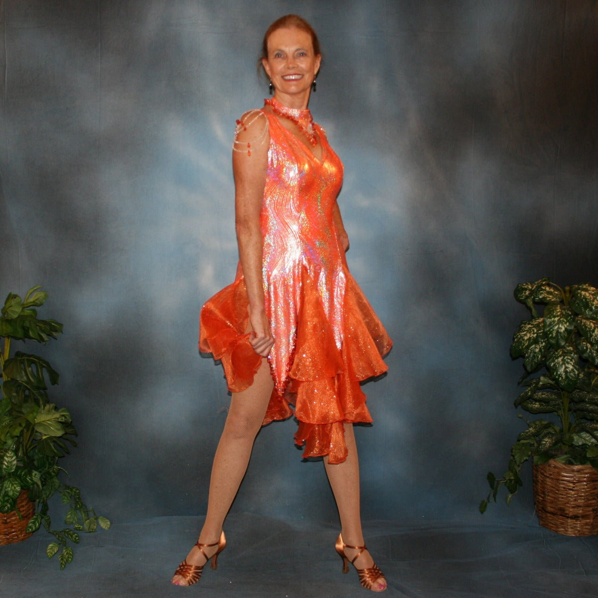 Crystal's Creations Orange Latin/rhythm dress was created in orange & silver metallic print lycra with oodles of glitter organza flounces & accents, has back strap detailing, embellished with extensive Swarovski hand beading & has matching Swarovski hand beaded neckpiece.