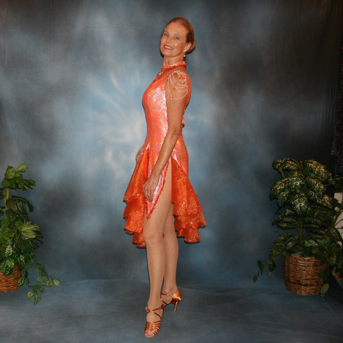 Crystal's Creations side view of orange Latin dress created in orange & silver metallic lycra with orange glitter organza flounces