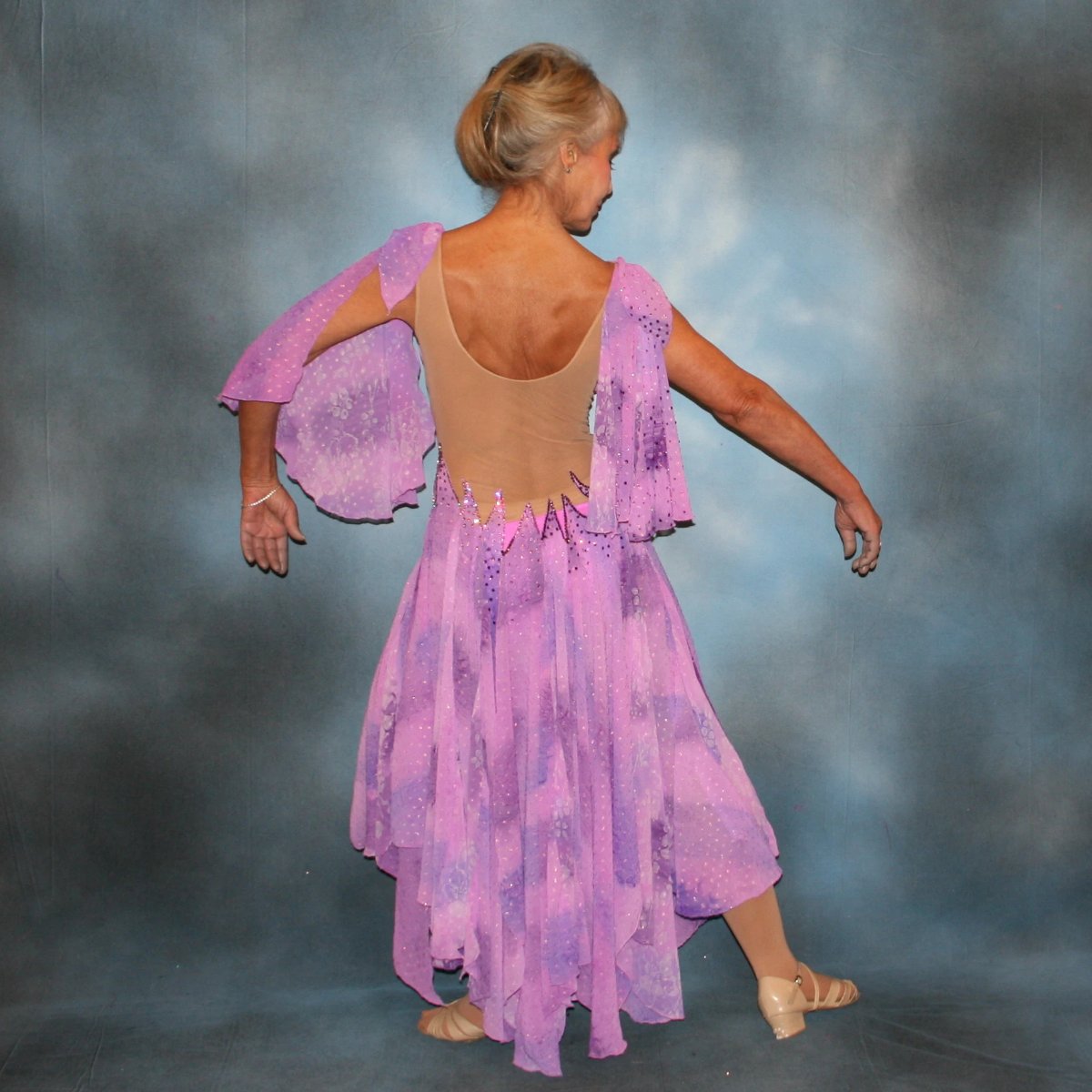 Crystal's Creations back view of Orchid ballroom dress created in yards of a textured chiffon in shades of orchids & purples on a nude illusion base with floats & Swarovski stonework in gorgeous shades of orchids & purples.