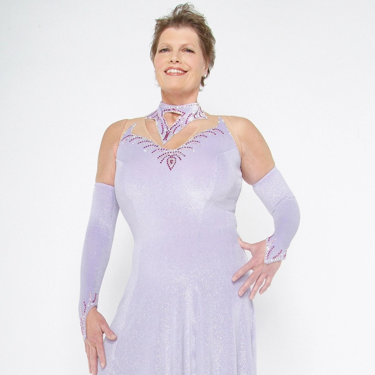 Crystal's Creations close view of Luxurious orchid ballroom dress was created in glitter velvet on nude illusion base, flairs out to sheer organza with sequined skirting. embellished with fuschia & CAB Swarovski rhinestone work. 
