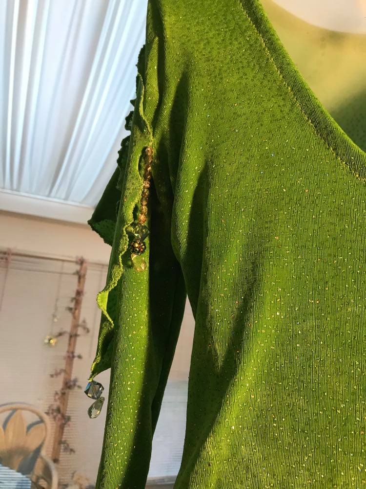 back shoulder detail of Apple green social Latin/rhythm dress was created of apple green glitter slinky, features ruching on the right side, long sleeves, scoop back, & full skirting with open side that has Swarovski hand beaded detail