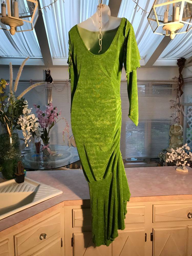 back view of Apple green social Latin/rhythm dress was created of apple green glitter slinky, features ruching on the right side, long sleeves, scoop back, & full skirting with open side that has Swarovski hand beaded detail