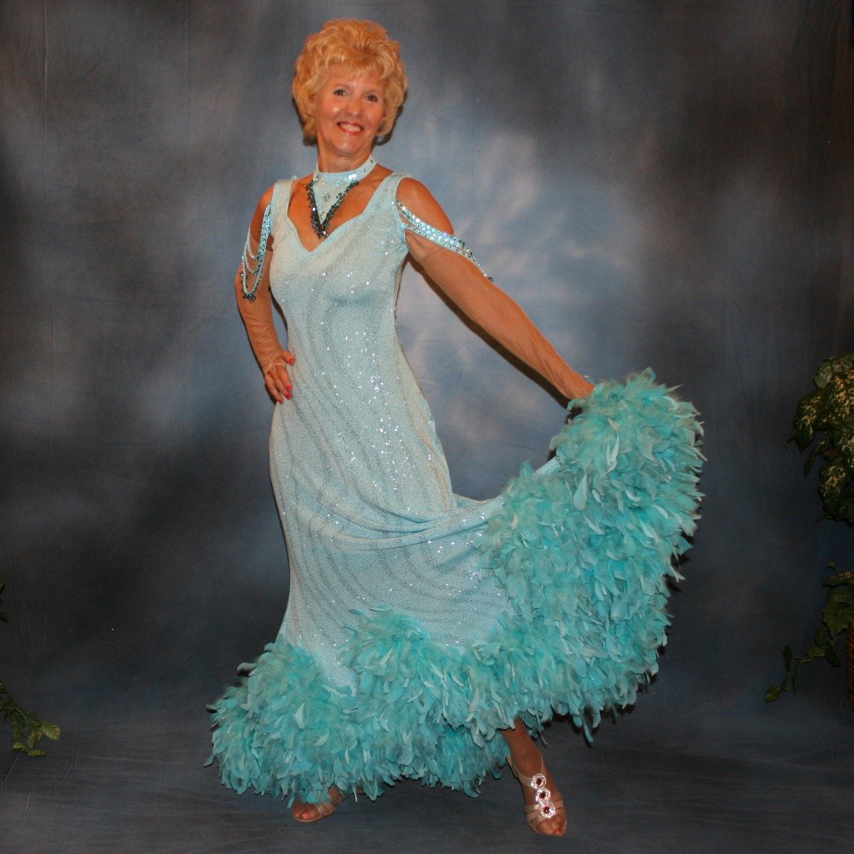 Soft blue ballroom dress with chandelle feathers was created of a gorgeous glitter slinky with a wave pattern, has strap detailing on the low back, embellished with Swarovski rhinestones & hand beading on the arm draping straps & matching neck piece.