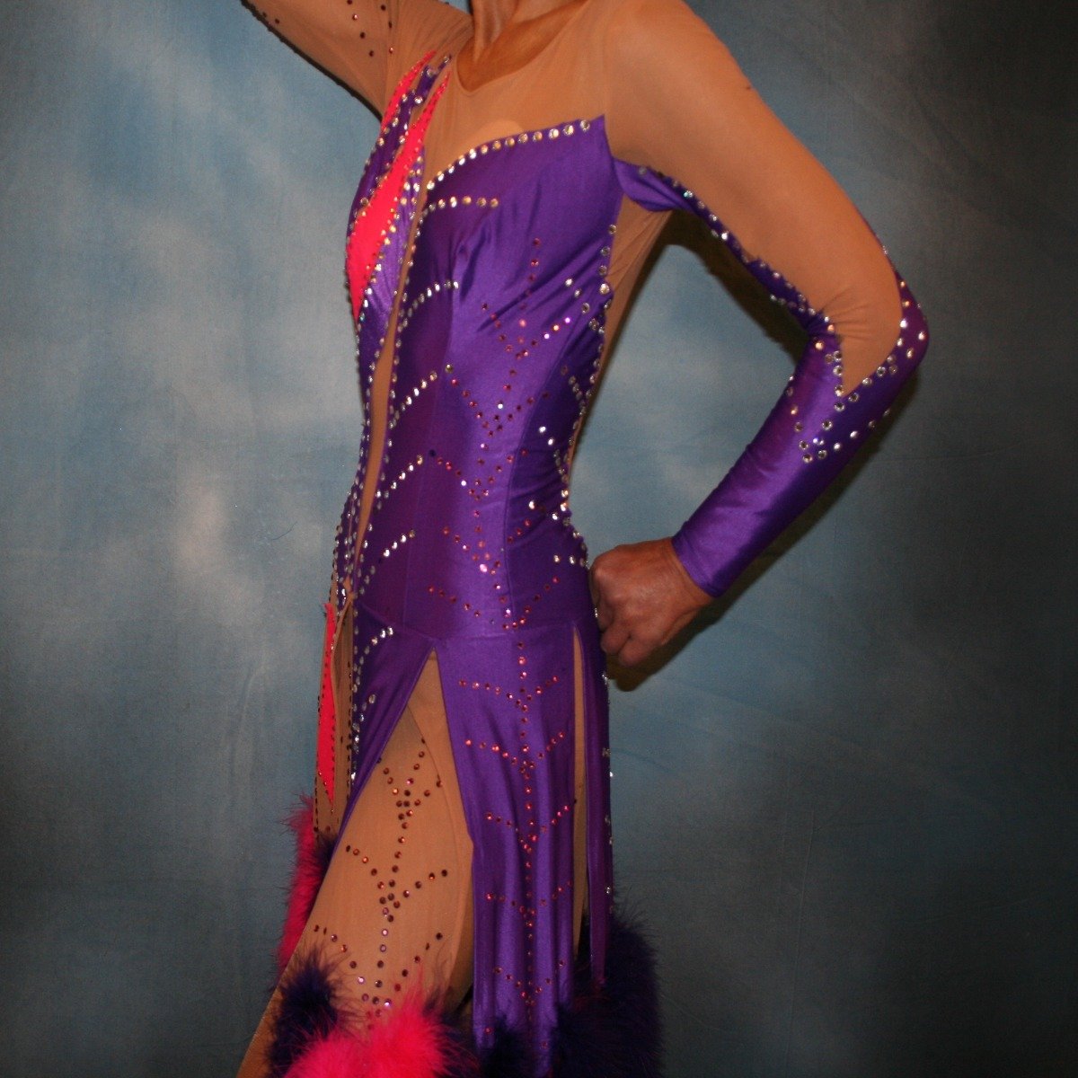 close left side of Crystal's Creations Purple & hot pink Latin/rhythm dress created of detailed artwork of purple & hot pink lycra on a nude illusion base, embellished with purple, fuchsia Swarovski rhinestone work, along with marabou feathers & hand beading.