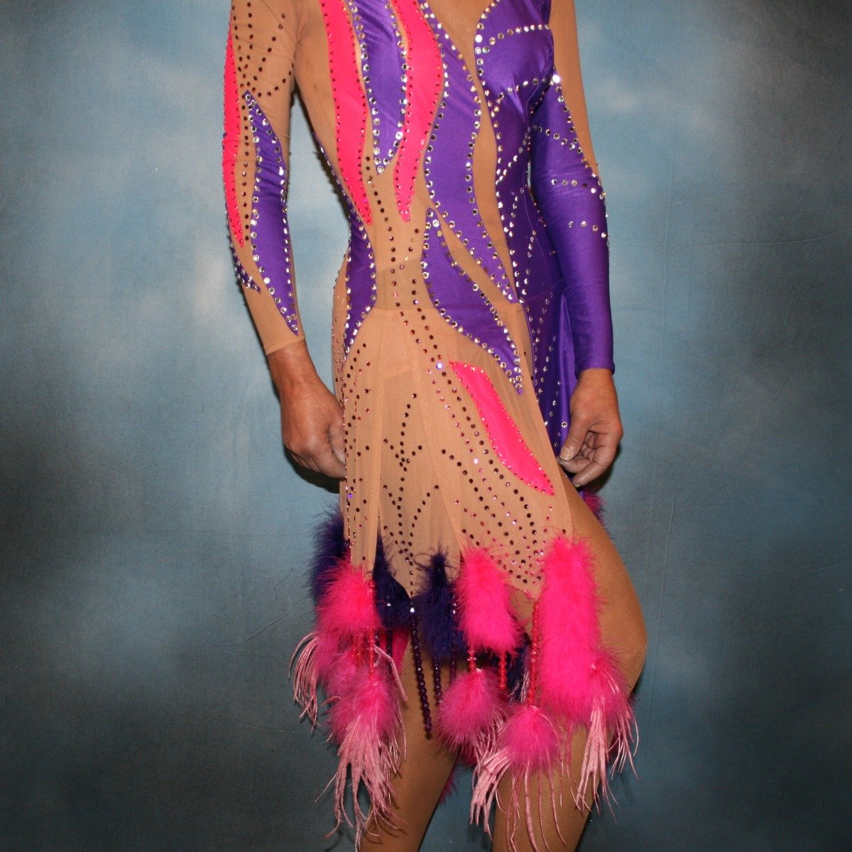close right side  view of Crystal's Creations Purple & hot pink Latin/rhythm dress created of detailed artwork of purple & hot pink lycra on a nude illusion base, embellished with purple, fuchsia Swarovski rhinestone work, along with marabou feathers & hand beading.