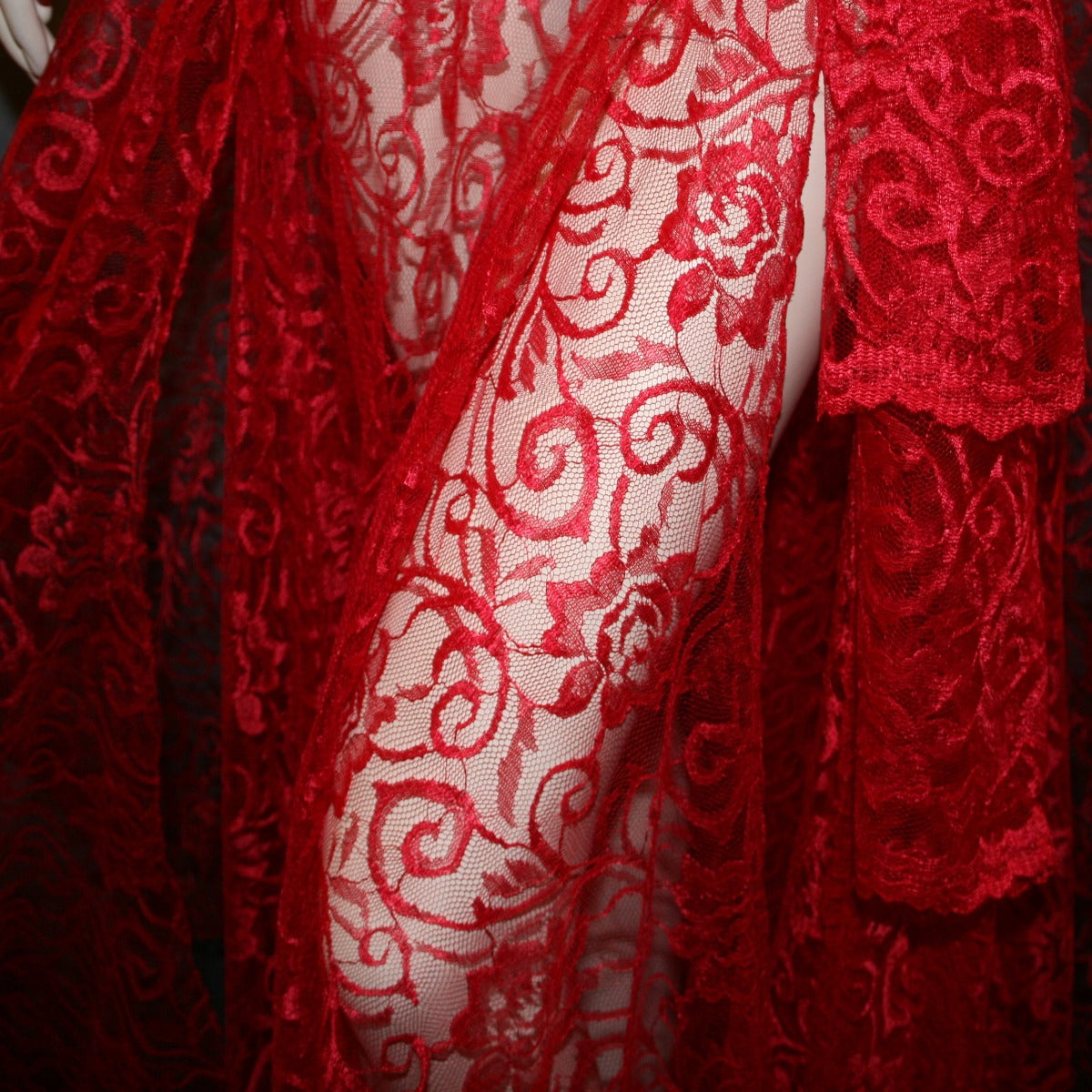 close view of Red lace ballroom skirt, wrap style, was created with yards of red lace, many panels shaped like large petals.