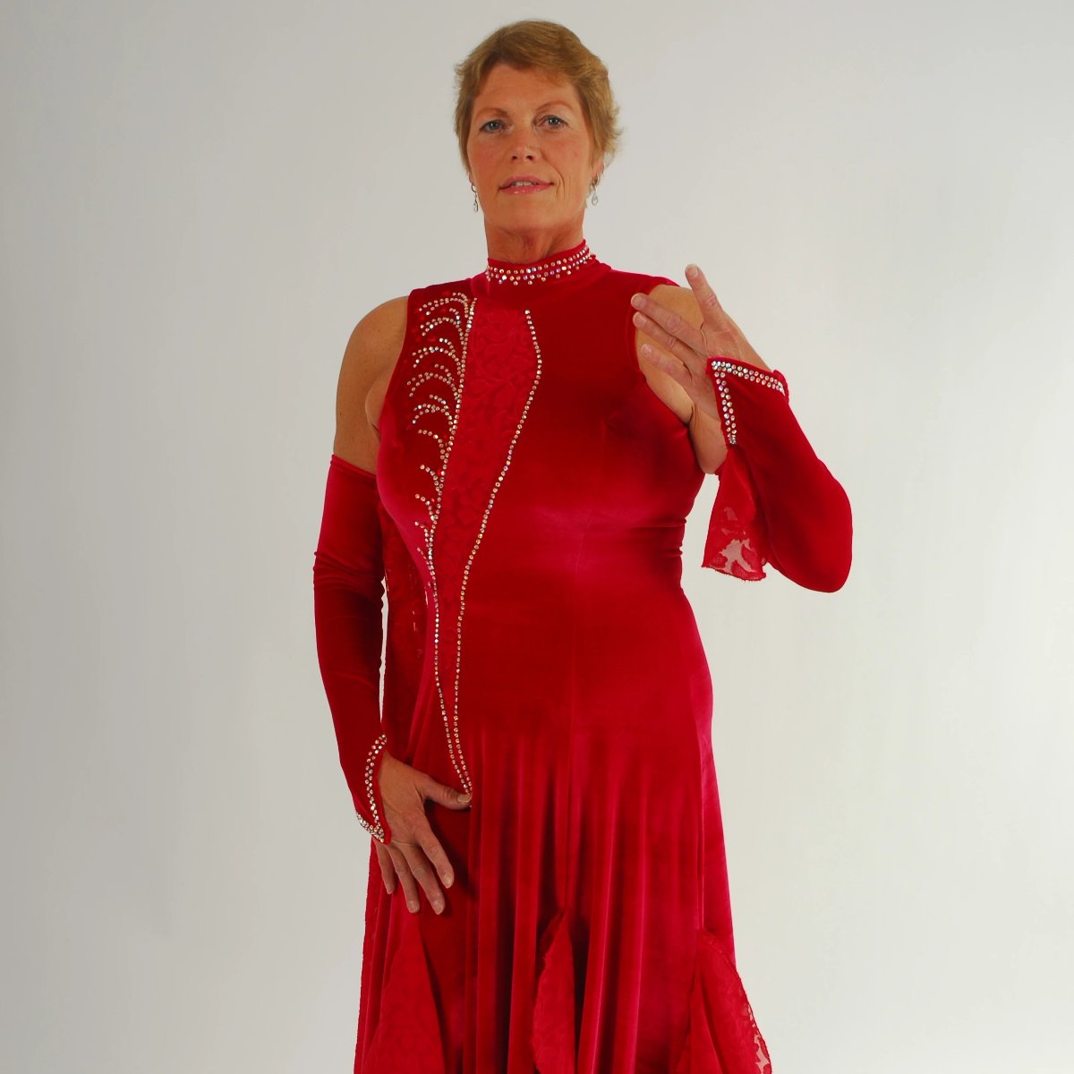close upper view of Red ballroom dress was created in luxurious red stretch velvet with clip-n-cut chiffon insets & flounces & inset down bodice with matching gauntlets...embellished with CAB Swarovski rhinestones & has keyhole back. 