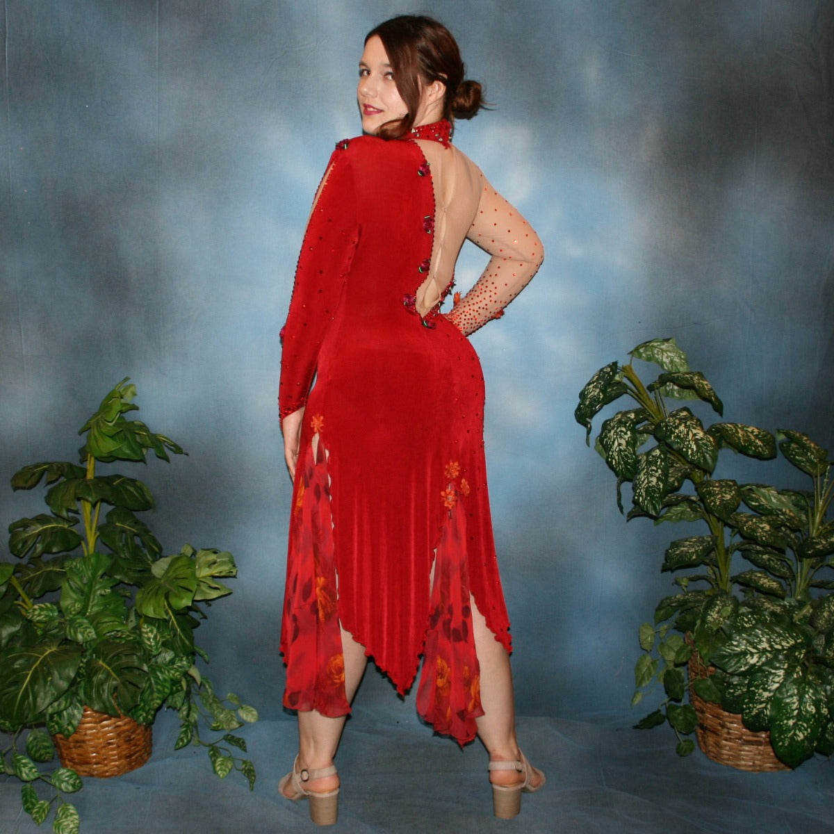 side back view of Red Latin/rhythm dance dress created in luxurious red solid slinky over nude illusion base with printed chiffon insets in skirting, is embellished with ruby & hyacinth Swarovski rhinestones plus silk roses.