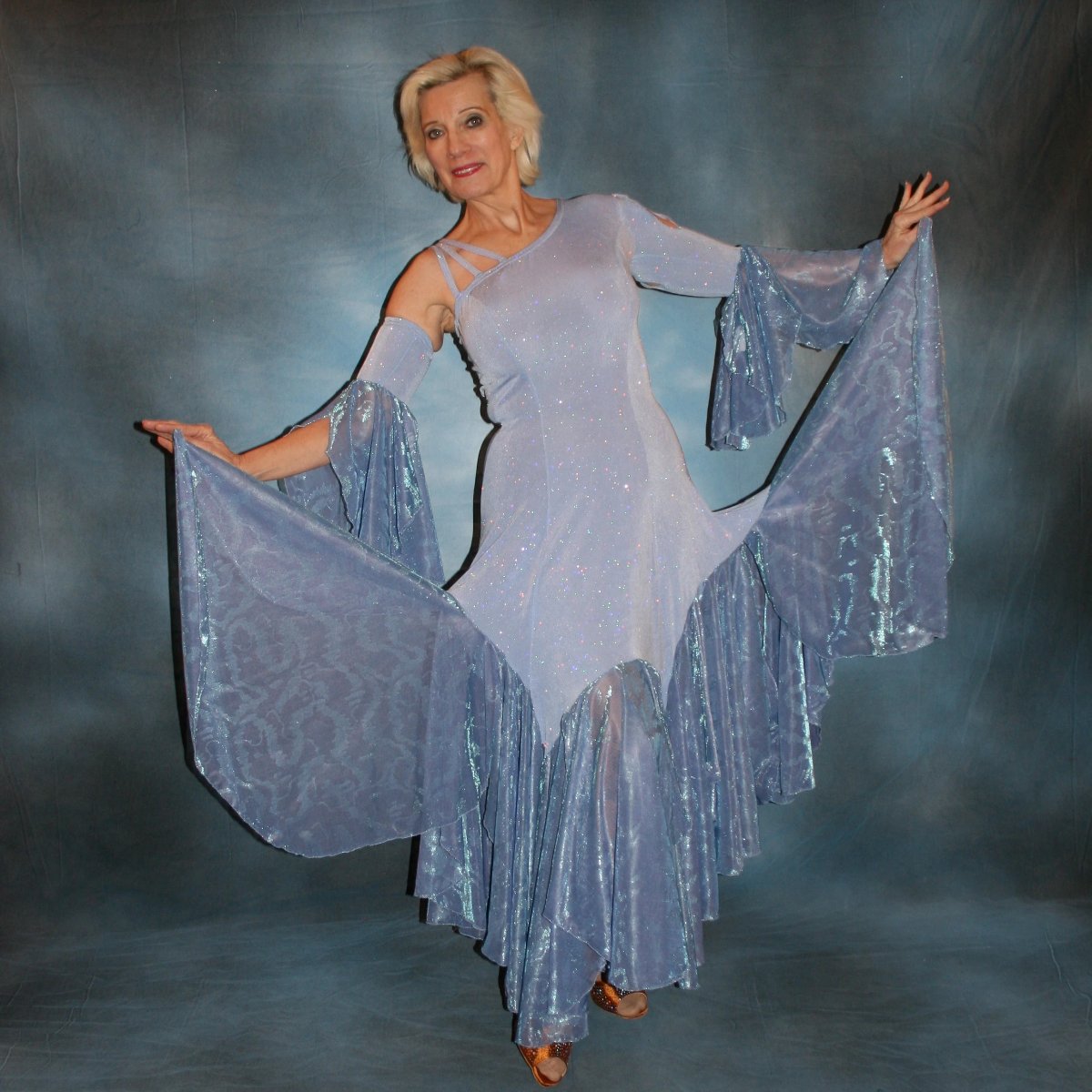 Crystal's Creations Periwinkle ballroom dress of glitter slinky with periwinkle iridescent sheer large skirt flounces with a subtle texture, one long sleeve, one arm embellishment with flounces & back detail straps… 