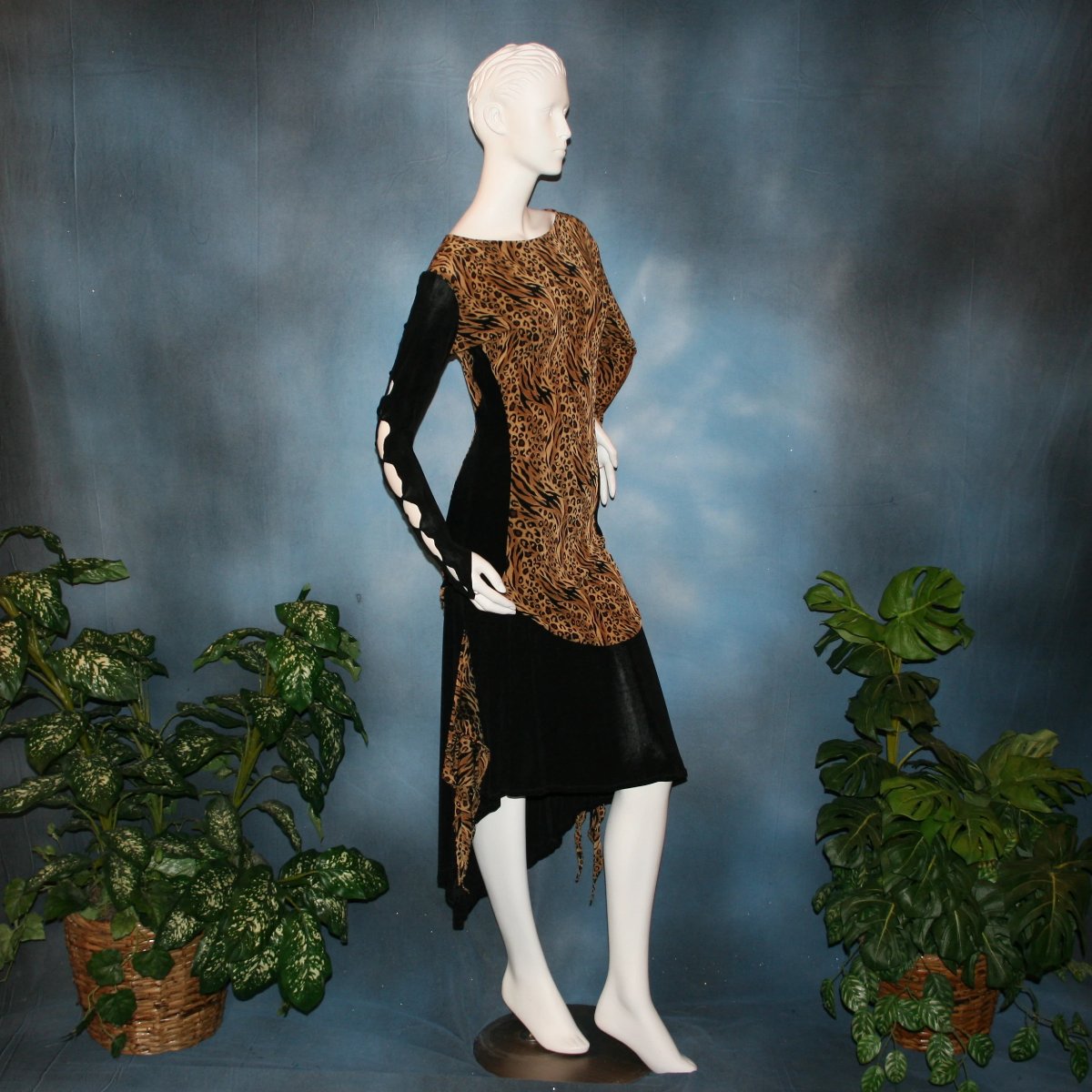 side view of Ballroom social slinky dance set consisting of a black slinky Latin/rhythm skirt with serengeti print slinky & matching tunic top with color blocking & open detailing work in the long sleeves. The tunic top can be worn separately as a Latin/rhythm dress with dance trunks or a shorter little skirt can be custom made to go with it for an extra fee. You can also team the slinky tunic with pants. This slinky Latin/rhythm skirt & top is great for ballroom teachers!