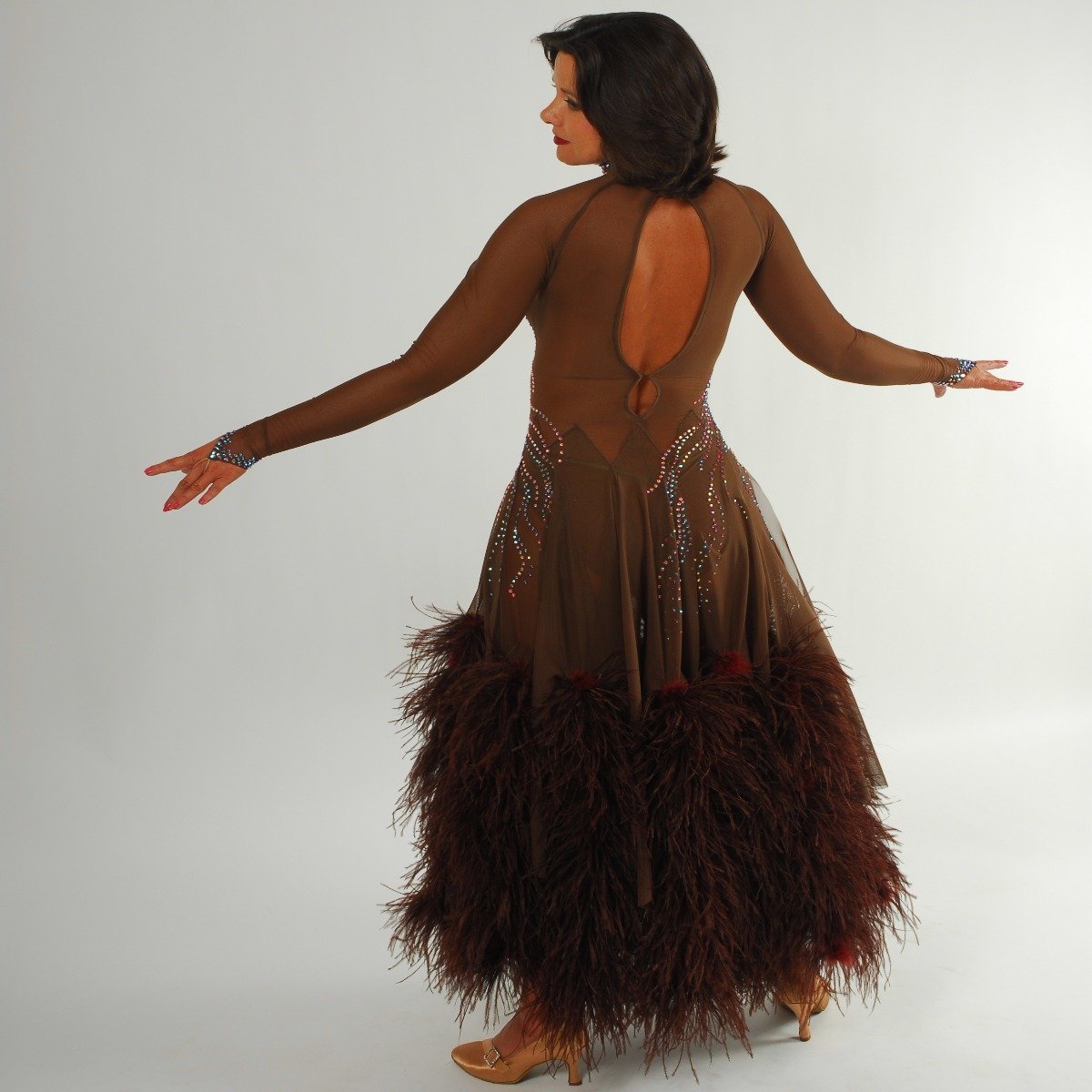 Crystal's Creations back view of brown ballroom dress created of brown sheer mesh illusion with detailed Swarovski rhinestone work in aqua Abs & brown ostrich feathers