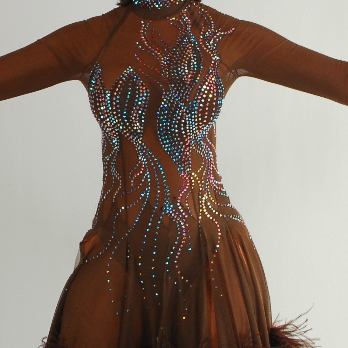 Crystal's Creations close up view of brown ballroom dress created of brown sheer mesh illusion with detailed Swarovski rhinestone work in aqua Abs & brown ostrich feathers