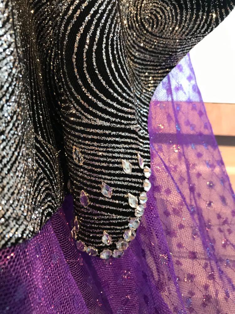Crystal's Creations bottom detail view of Silver & black converta ballroom dress was created on a nude illusion base of silver swirls glitter slinky intricately cut & placed & is embellished with delicate flower shaped crystal Preciosa rhinestones, as well as tear drop shaped crystal Swarovski rhinestones! The main dress itself is fabulous for a ballroom dance all around division. It comes with 4 different skirts size 1/2-3/4