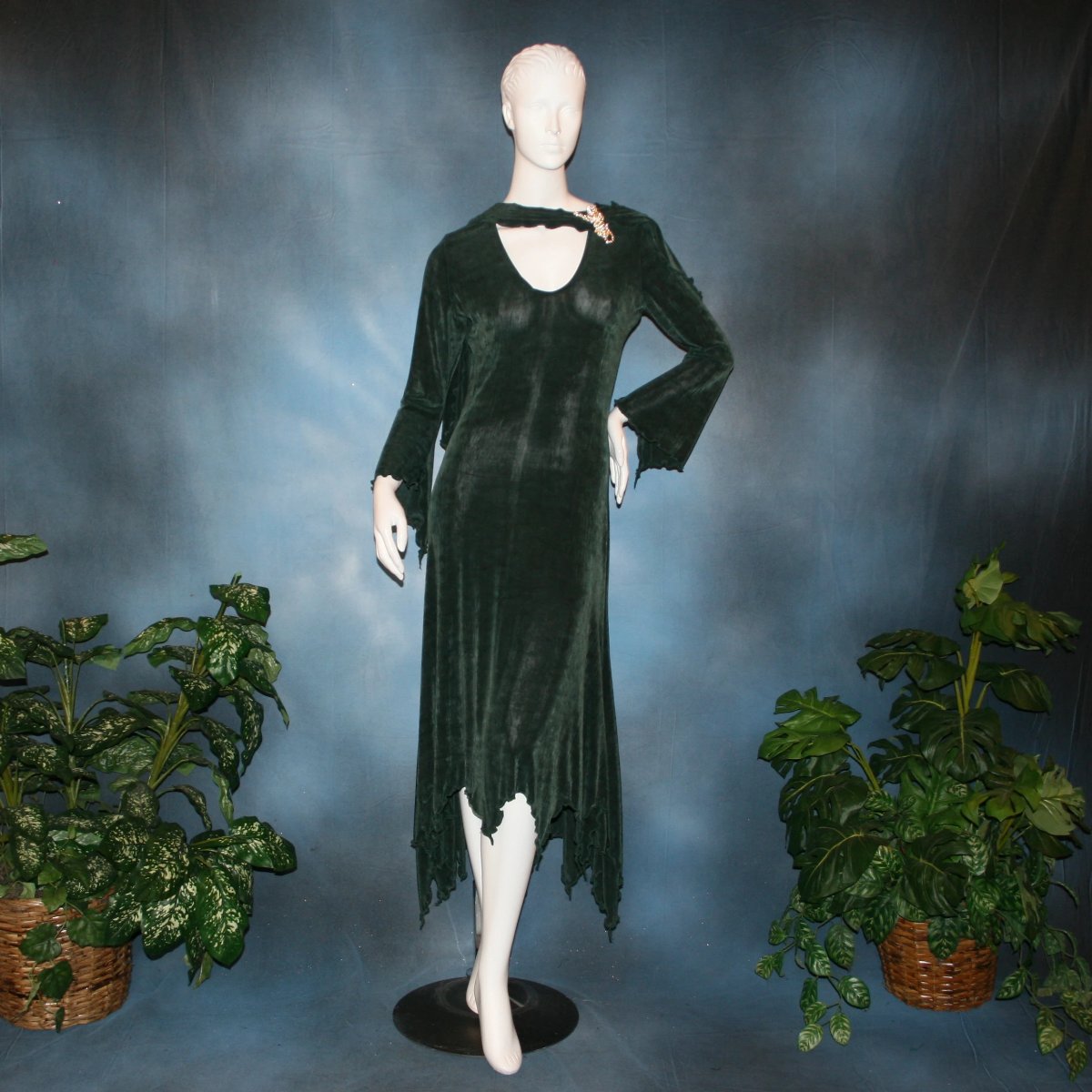 Deep green social ballroom dress created in luxurious solid slinky fabric with attached draping on shoulders & peaked skirt edge. Very full around bottom..can be a beginner ballroom dancer smooth ballroom dress. Broach is not included. This ballroom social dress can be custom created in many colors.