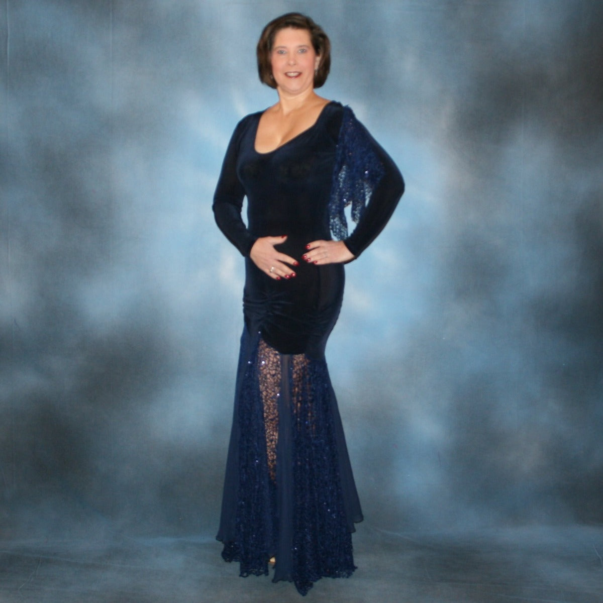 Crystal's Creations side view of Ballroom dress created in luxurious navy blue solid slinky fabric with yards of gorgeous unique sequined mermaid net look lace & chiffon. The bottom of base of dress has ruching at the hip. A great social dress for any ballroom dance or special occasion, as well as a great beginner show dress!