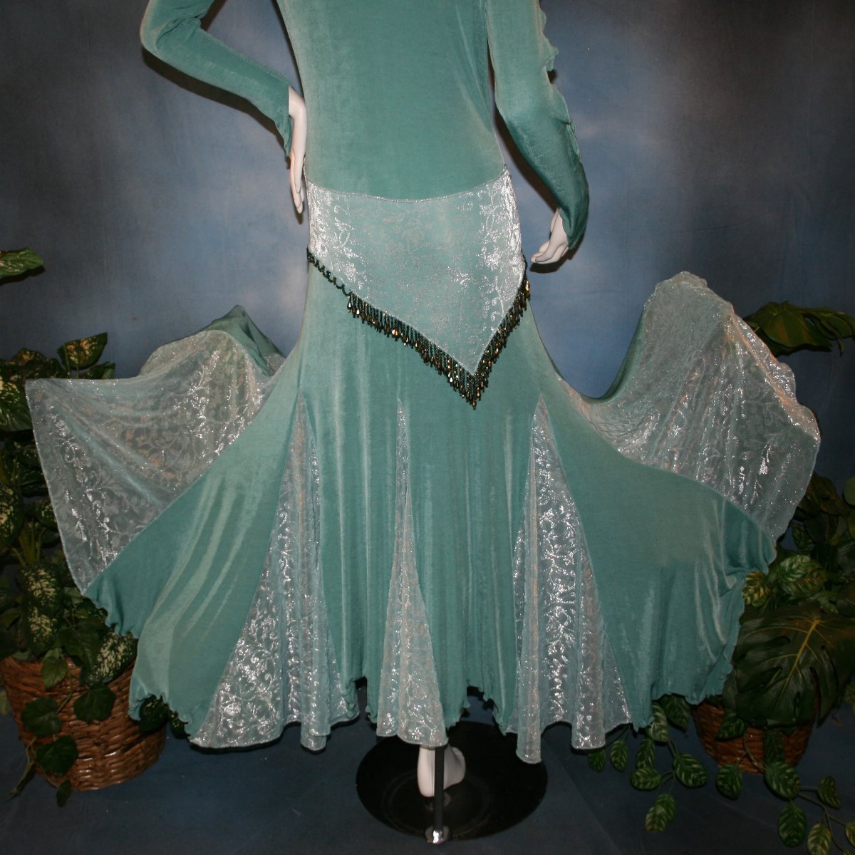 lower view of Aqua social ballroom dress created in luxurious aqua solid slinky fabric with aqua iridescent sheer insets, embellished with hand beading of Swarovski beads on hip sash. Very full around bottom...can be a beginner ballroom dancer smooth ballroom dress.