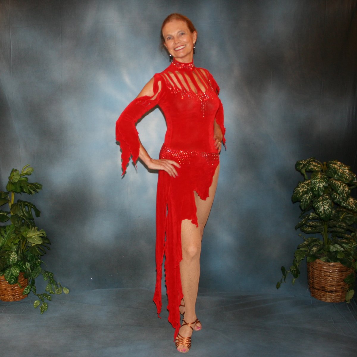 Crystal's Creations Red Latin/rhythm dress, which consists of a bodysuit, featuring cutouts in bodice with a keyhole back, 3/4 sleeves with details & Latin/rhythm skirt, was created in luxurious red solid slinky embellished with light siam Swarovski rhinestone work.