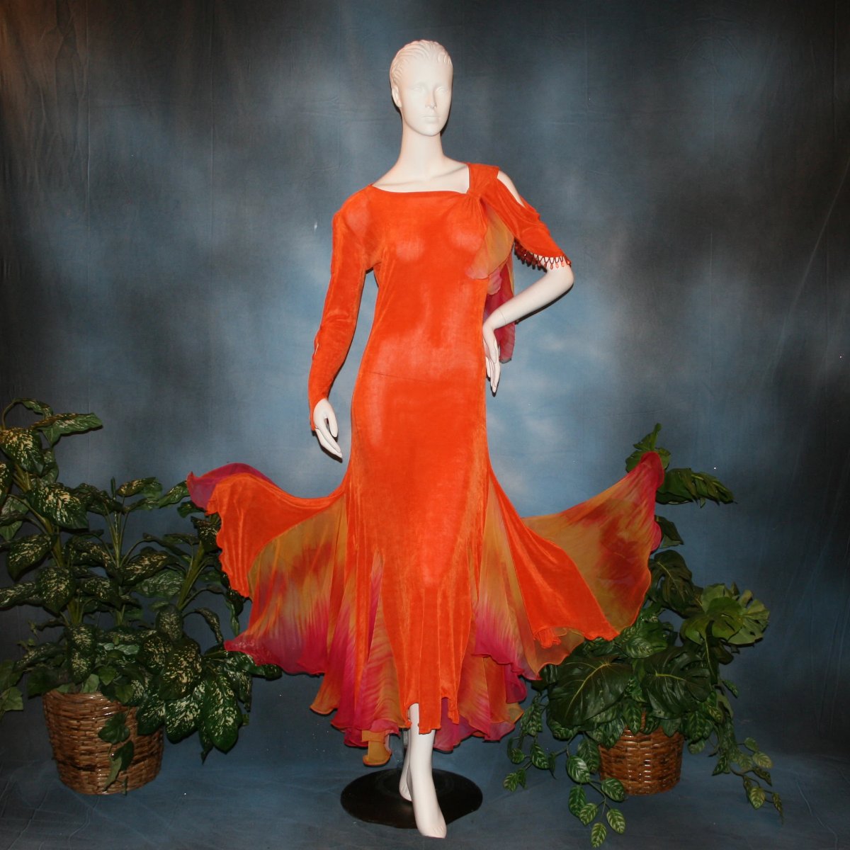 Orange social ballroom dress created in luxurious solid slinky fabric with chiffon insets of rainbow oranges & yellows, with hand beading on arm draping. Very full around bottom, and makes a great beginner ballroom dancer smooth dress.