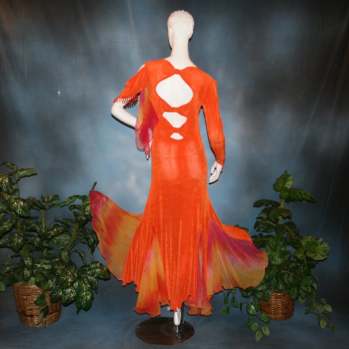 back view of Orange social ballroom dress created in luxurious solid slinky fabric with chiffon insets of rainbow oranges & yellows, with hand beading on arm draping. Very full around bottom, and makes a great beginner ballroom dancer smooth dress.