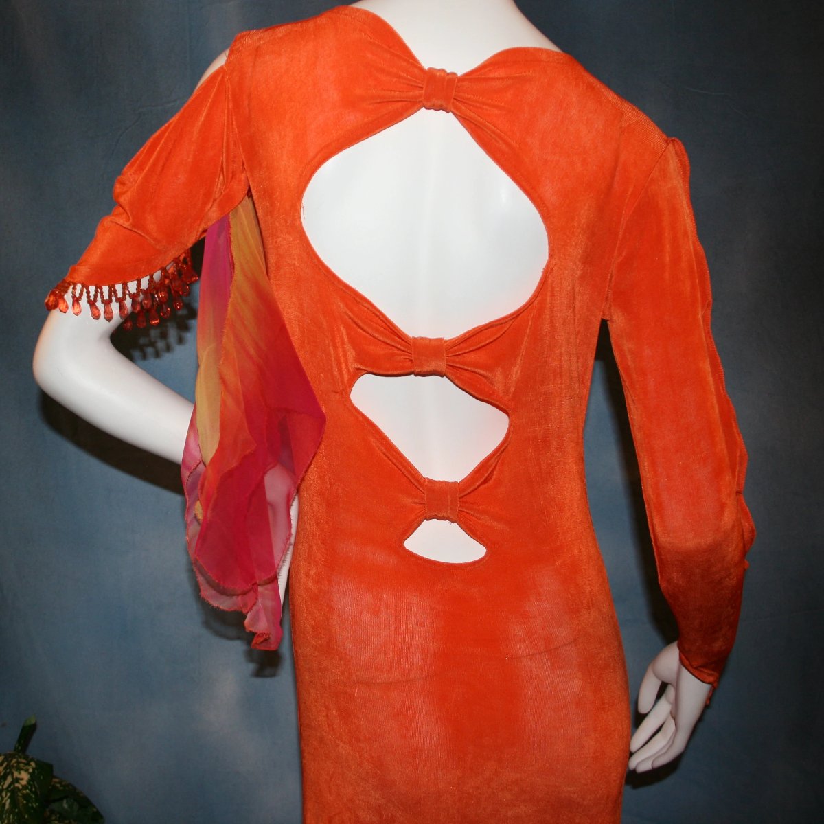 upper back close view of Orange social ballroom dress created in luxurious solid slinky fabric with chiffon insets of rainbow oranges & yellows, with hand beading on arm draping. Very full around bottom, and makes a great beginner ballroom dancer smooth dress.