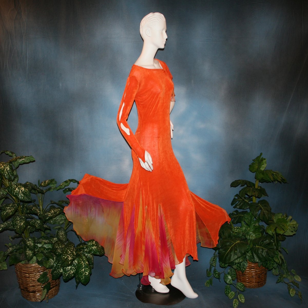 side view of Orange social ballroom dress created in luxurious solid slinky fabric with chiffon insets of rainbow oranges & yellows, with hand beading on arm draping. Very full around bottom, and makes a great beginner ballroom dancer smooth dress.
