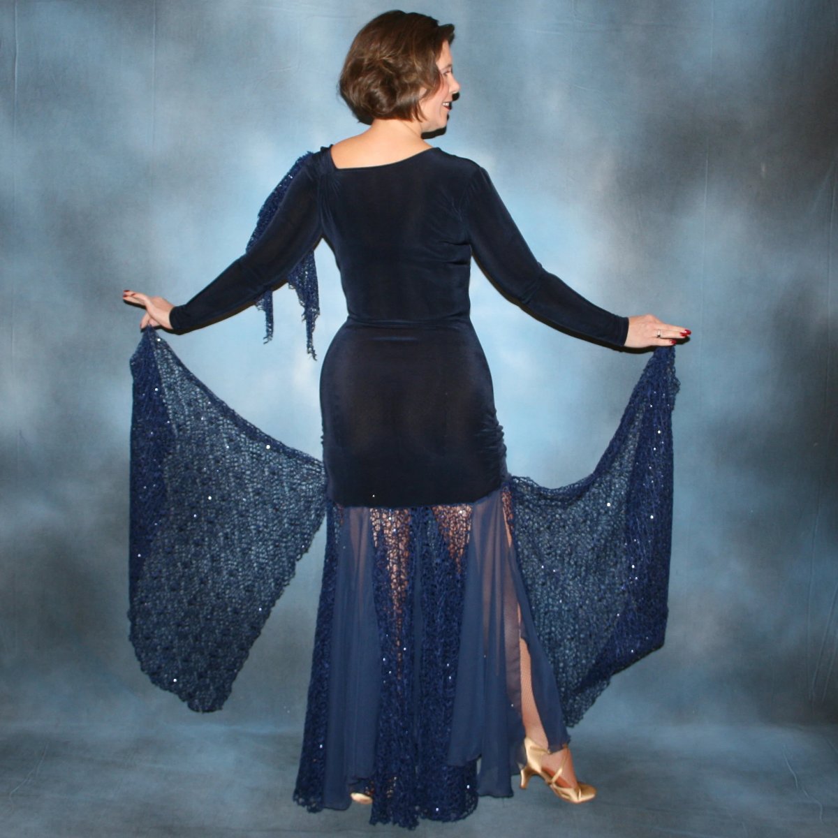 Crystal's Creations back view of Ballroom dress created in luxurious navy blue solid slinky fabric with yards of gorgeous unique sequined mermaid net look lace & chiffon. The bottom of base of dress has ruching at the hip. A great social dress for any ballroom dance or special occasion, as well as a great beginner show dress!