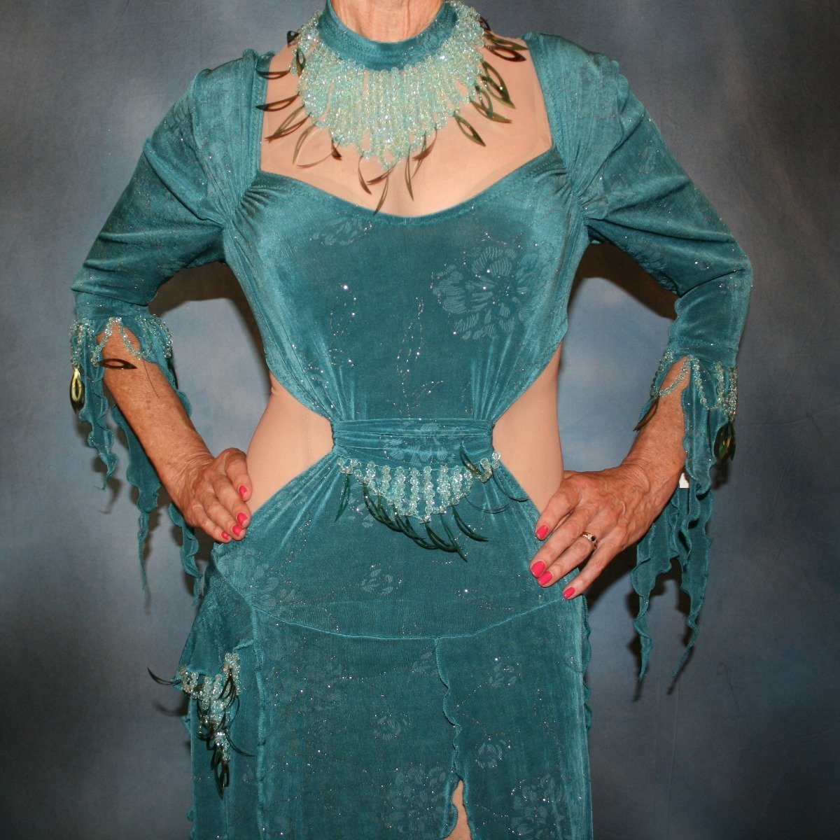 Crystal's Creations close up view of Teal Latin/rhythm dress was created in teal glitter slinky with a subtle gold glitter floral print, embellished with light teal faceted round lucite beading & teal spangles, includes a matching neckpiece.
