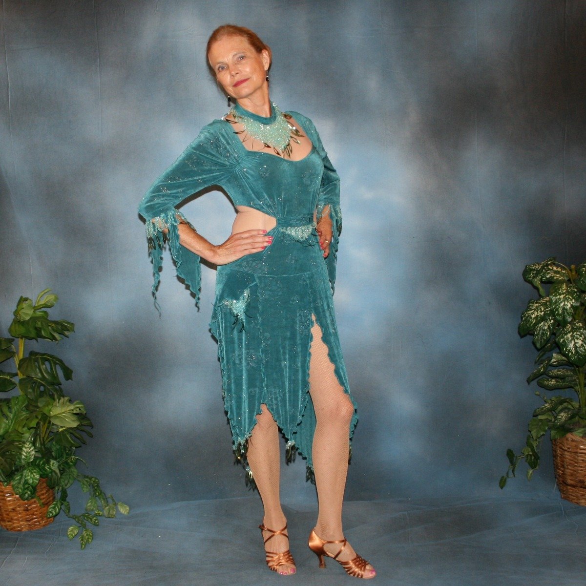 Crystal's Creations side view of Teal Latin/rhythm dress was created in teal glitter slinky with a subtle gold glitter floral print, embellished with light teal faceted round lucite beading & teal spangles, includes a matching neckpiece.