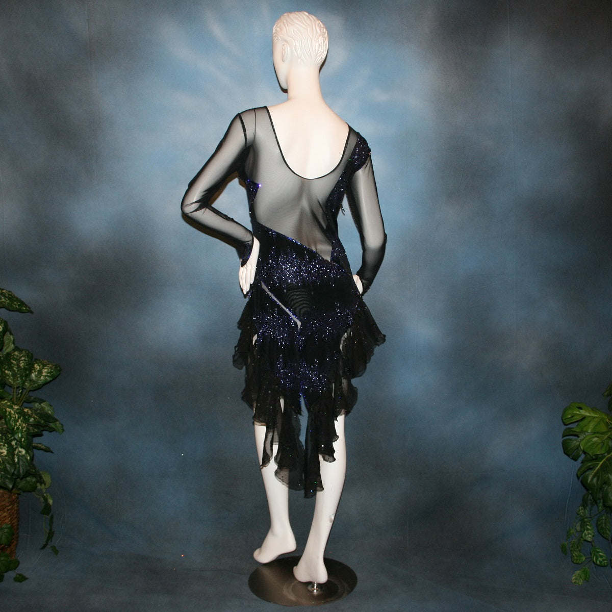 Crystal's Creations back view of Latin/rhythm/tango dress created in black glitter slinky with an awesome electrifying tanzanite/perwinkle glitter pattern artistically placed on a black stretch mesh base, embellished with crystal heliotrope Preciosa rhinestone work, hand beading & features flounces in the back skirting.