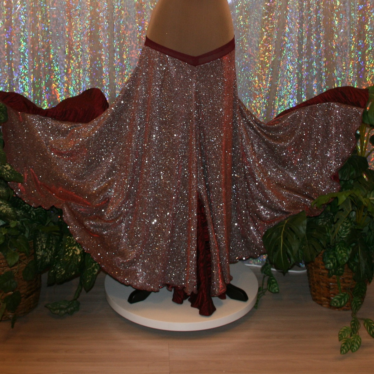 back view of Ballroom dance skirt created of a very sparkly knit that shimmers silver & wine colors with insets of a 3 color pleated satin that looks wine colored with this particular fabric. 