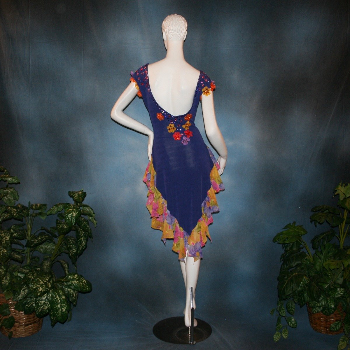 Crystal's Creations back view of Converta ballroom dress featuring a Latin/rhythm dress created in luxurious deep perwinkle solid slinky with lots of flounces in accents of a floral chiffon in yellow with pinks & purples