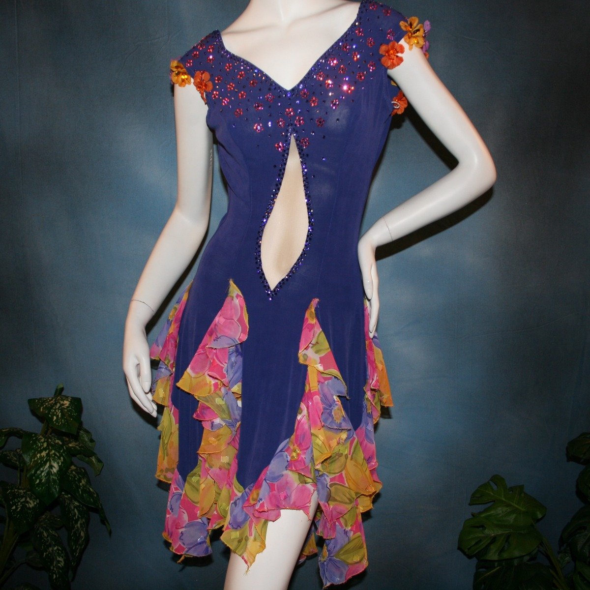 Crystal's Creations close up view of Converta ballroom dress featuring a Latin/rhythm dress created in luxurious deep perwinkle solid slinky with lots of flounces in accents of a floral chiffon in yellow with pinks & purples