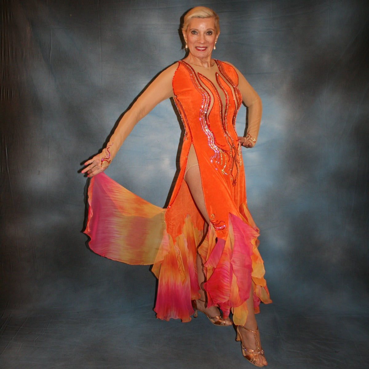 Crystal's Creations Sunny orange ballroom dress created in luxurious solid slinky with gorgeous printed chiffon in bursts of orange, pink & yellow, is embellished with Swarovski rhinestone work of orange hyacynth, rose, jonquil & fuschia. 