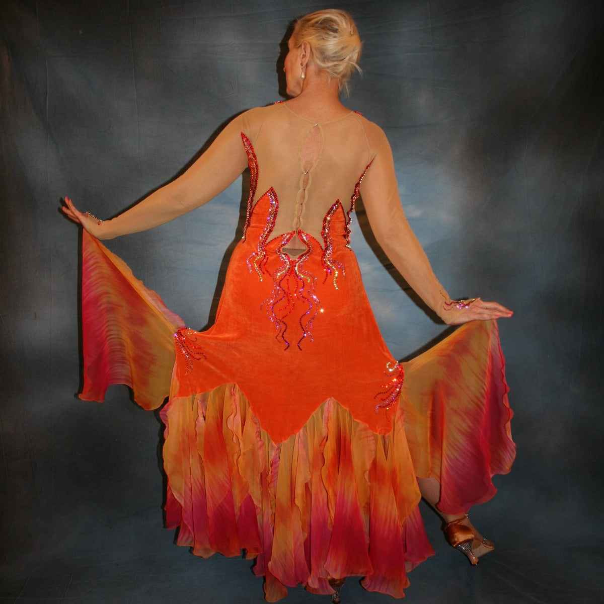 Crystal's Creations back view of Sunny orange ballroom dress created in luxurious solid slinky with gorgeous printed chiffon in bursts of orange, pink & yellow, is embellished with Swarovski rhinestone work of orange hyacynth, rose, jonquil & fuschia. 