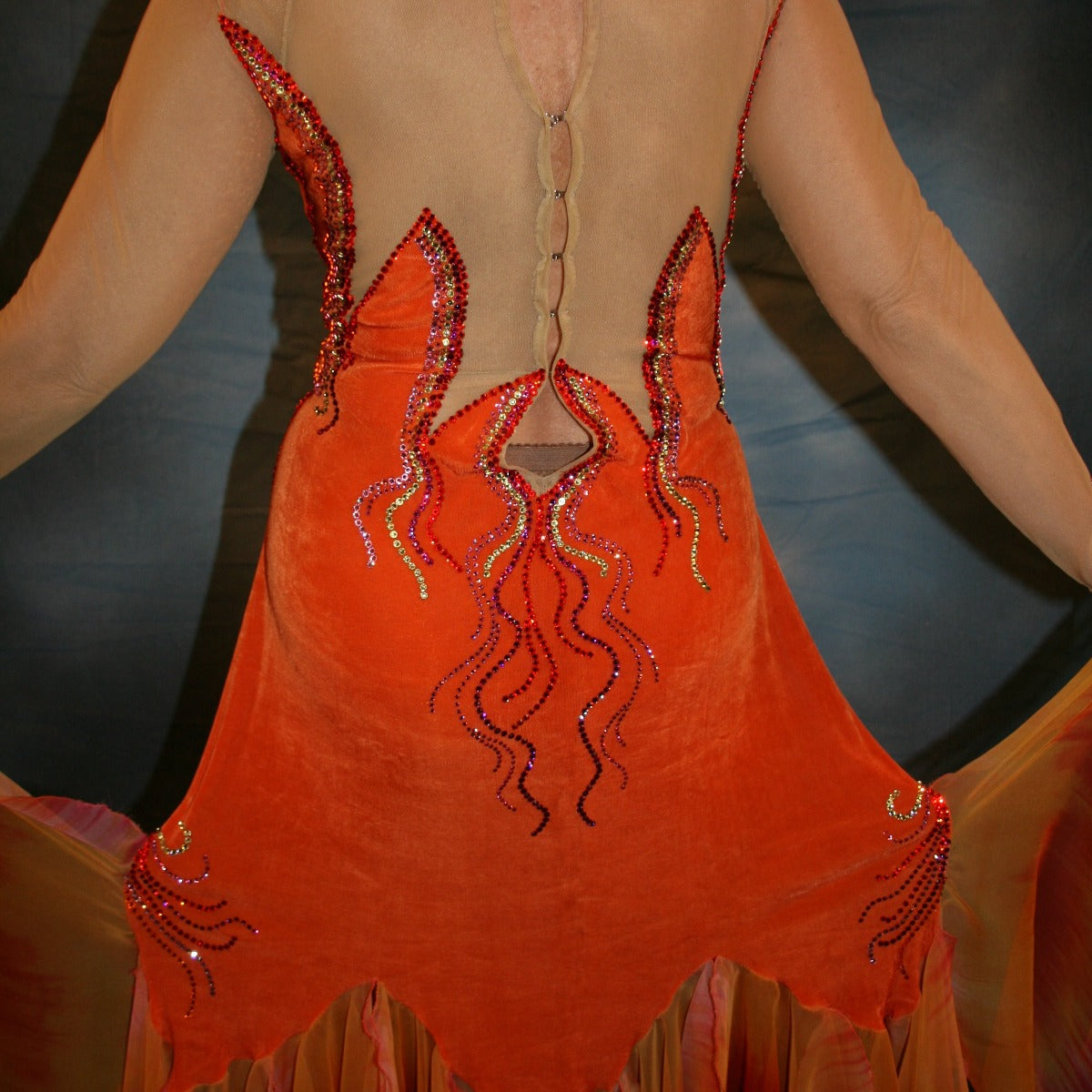 Crystal's Creations close up back view of Sunny orange ballroom dress created in luxurious solid slinky with gorgeous printed chiffon in bursts of orange, pink & yellow, is embellished with Swarovski rhinestone work of orange hyacynth, rose, jonquil & fuschia. 