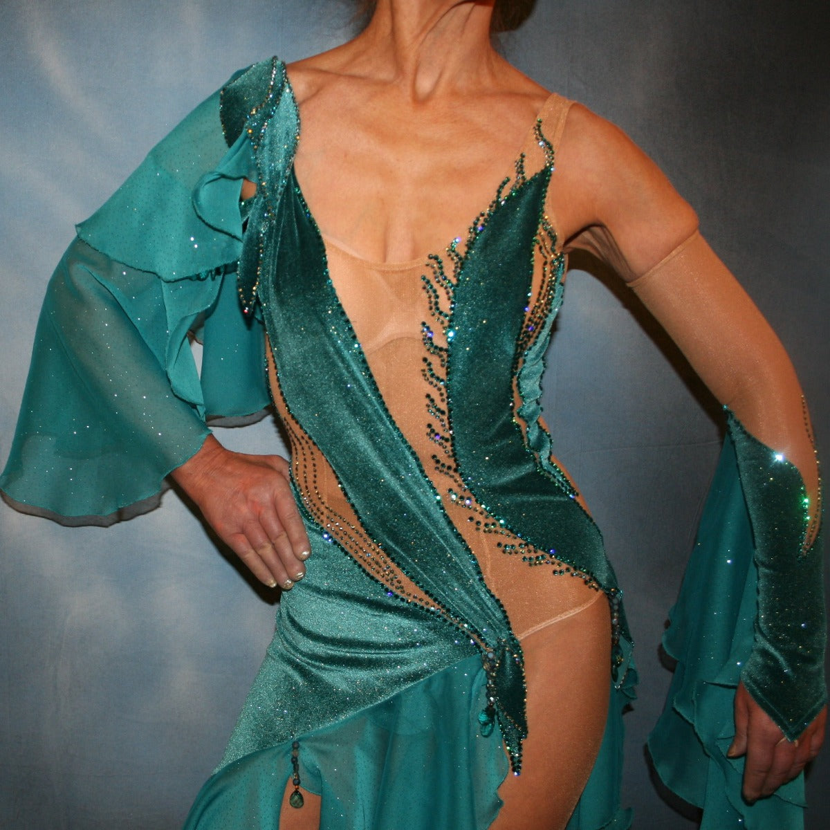 Crystal's Creations close up view of Crystal's Creations close up view of Teal Latin/rhythm dress was created on a nude illusion base with luxurious teal glitter stretch velvet fabric along with flounces of teal glitter chiffon, embellished with blue zircon & blue zircon Ab Swarovski stonework plus hand beaded detailing