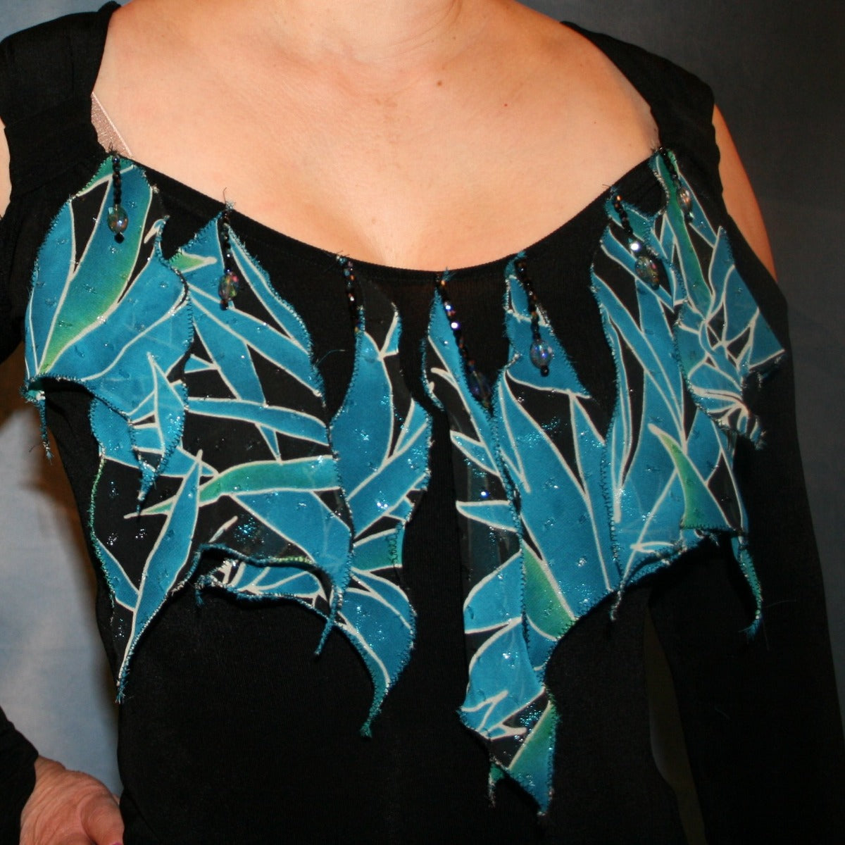 Crystal's Creations close up view of details of black converta ballroom dress created in luxurious black slinky with turquoise, green & black tropical print