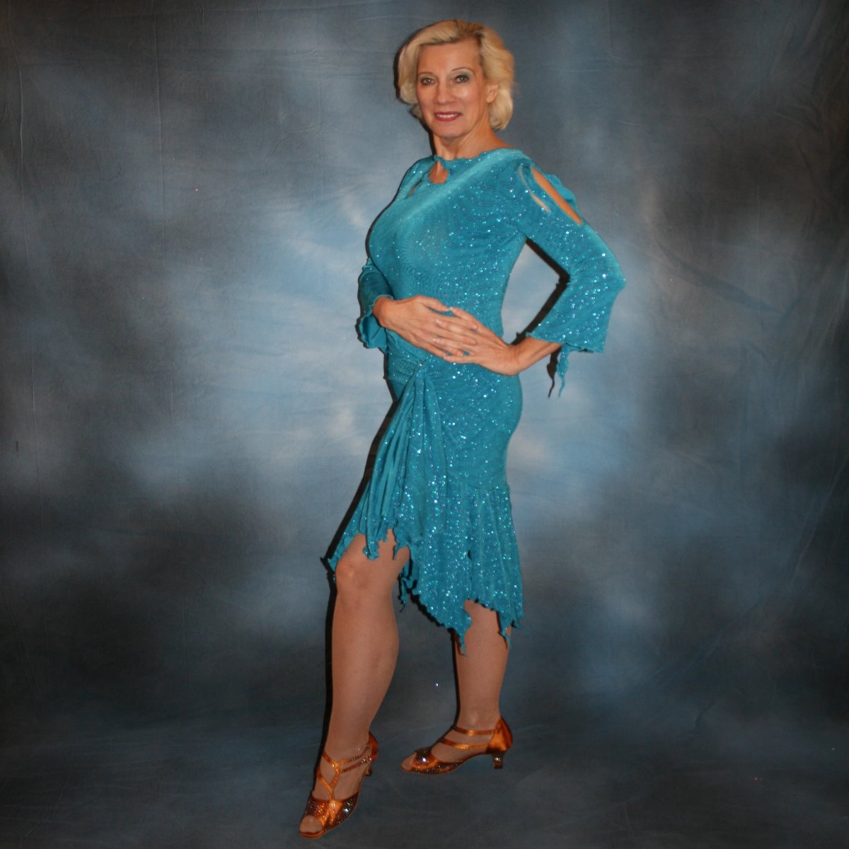 left side view of Turquoise Latin/rhythm skirt & bodysuit featuring keyhole back & flaired sleeves of turquoise with a touch of purple glitterknit slinky,  only one of this exact fabric.