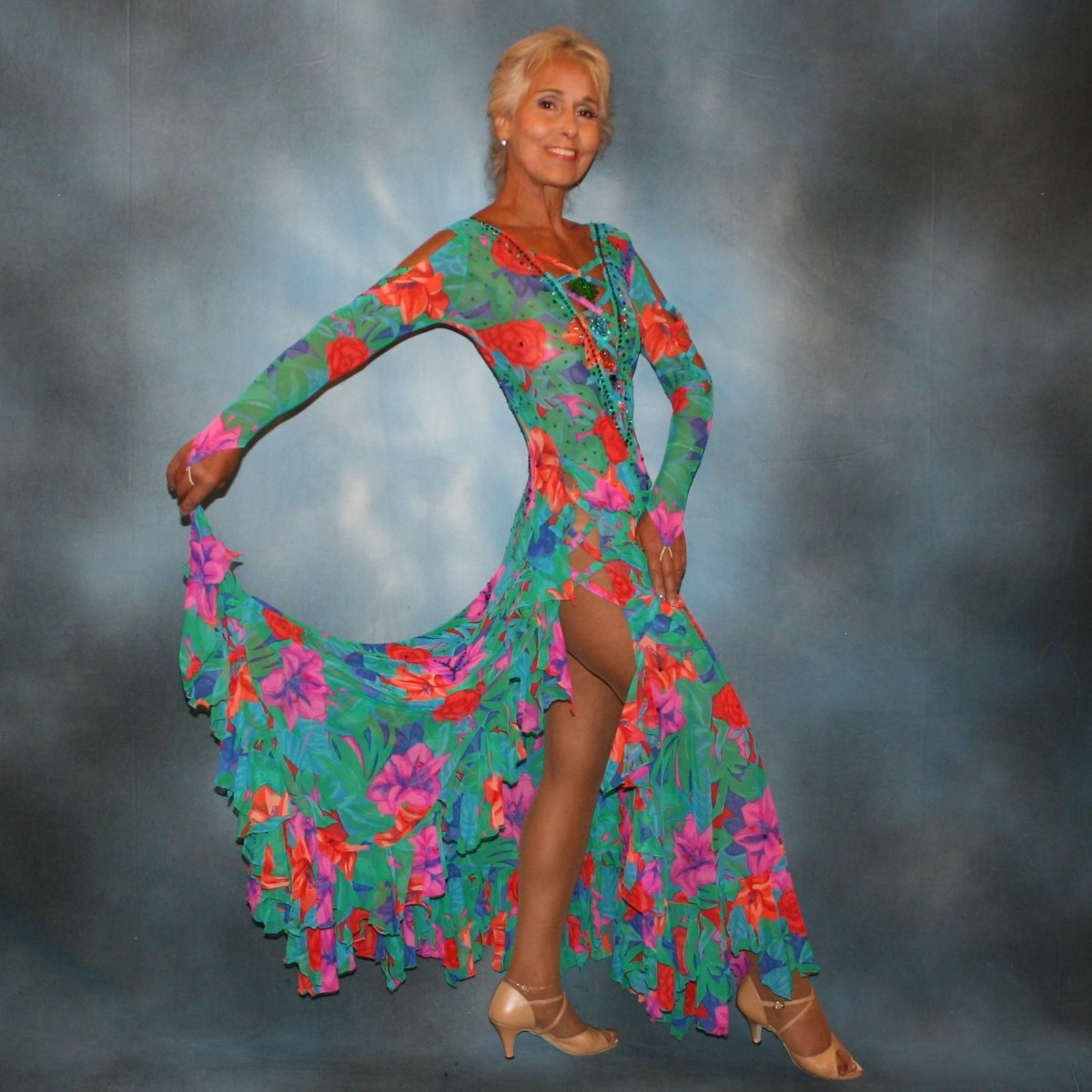 Crystal's Creations Gorgeous green tropical print Latin/rhythm dress with orange, pink & purple flowers in the print has lots of flounces up & around the high slit thighs, embellished with Swarovski rhinestone work, along with lattice strap detailing & hand beading.