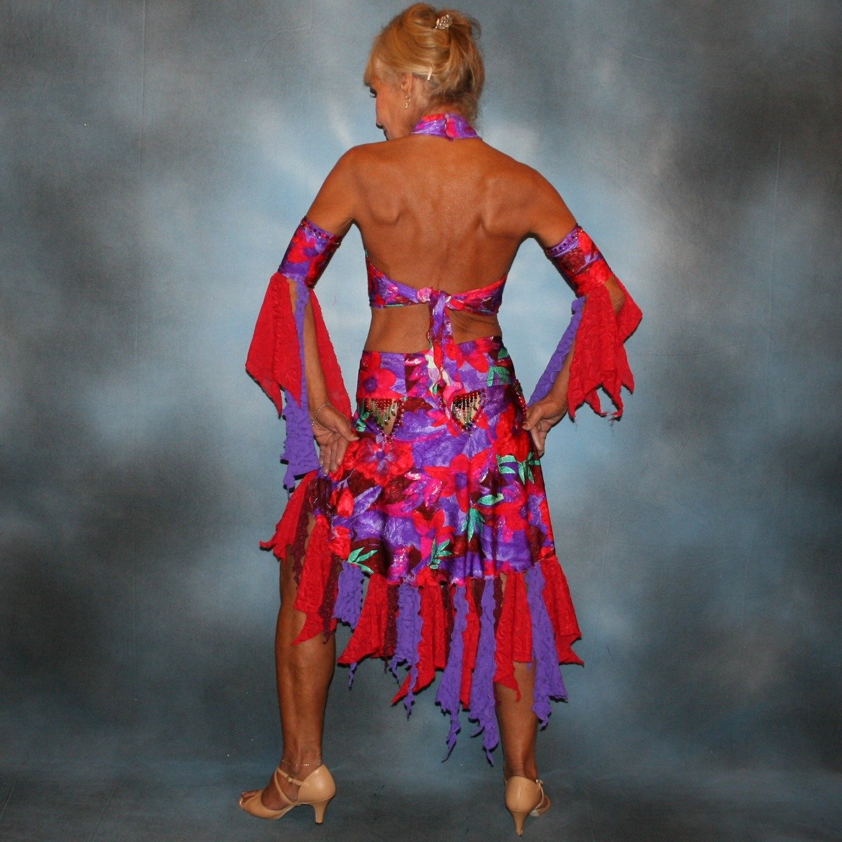 Crystals' Creations back view of Red & purple tropical print 2 piece Latin/rhythm dress was created in tropical print lycra in deep reds,purples & a touch of green, along with accents of deep red textured chiffon scarf cut flounces & purple stretch lace petal cut flounces on skirt and arm bands,