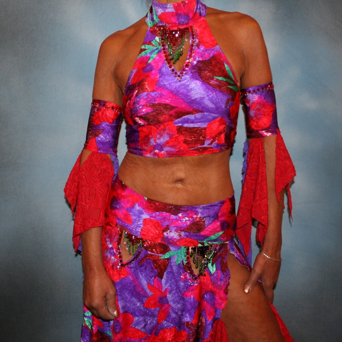 Crystal's Creations close up view of Red & purple tropical print 2 piece Latin/rhythm dress was created in tropical print lycra in deep reds,purples & a touch of green, along with accents of deep red textured chiffon scarf cut flounces & purple stretch lace petal cut flounces on skirt and arm bands,