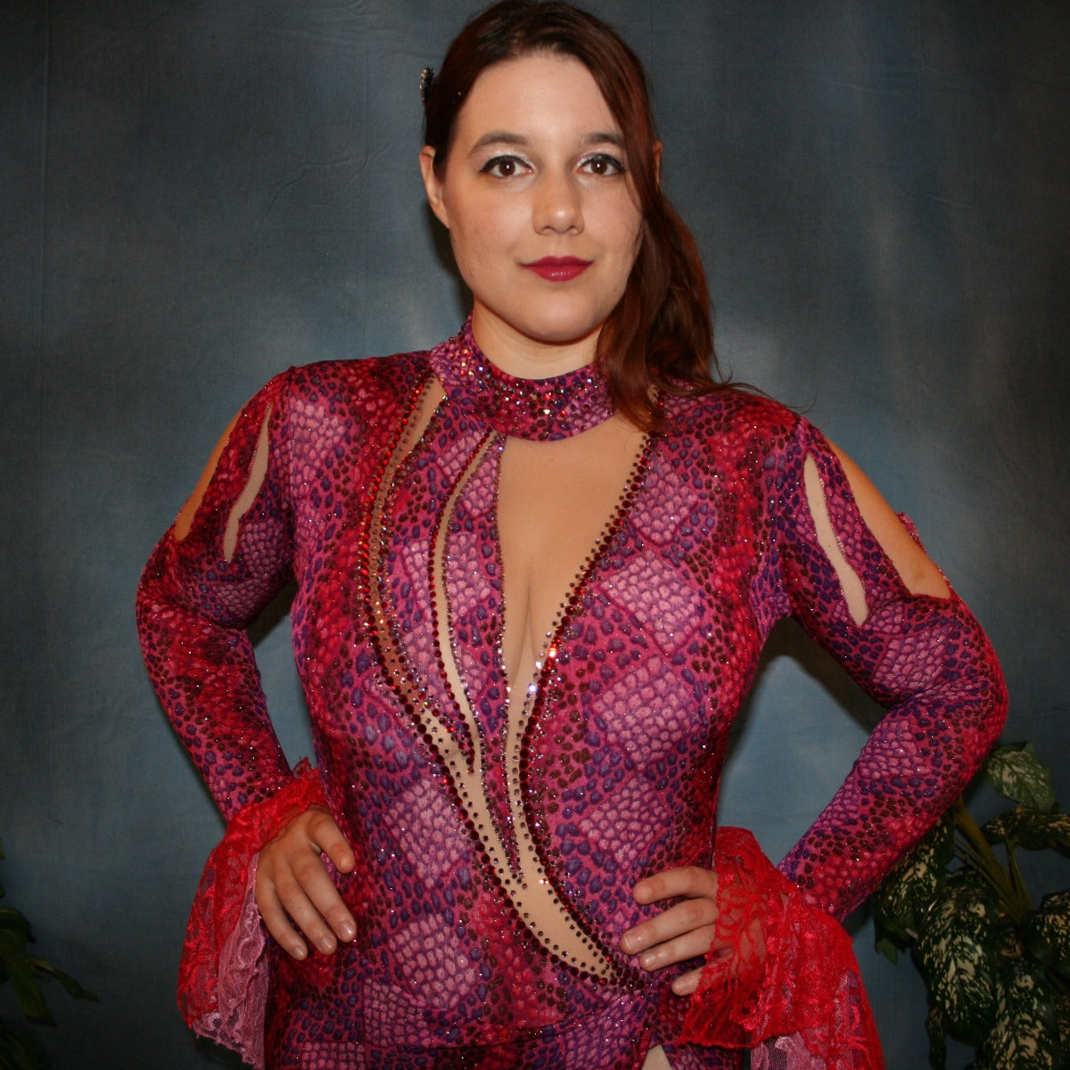 Crystal's Creations close up view of Red & purple Latin/rhythm dress created in gorgeous printed slinky glitterknit in reptilia print of reds, purples & orchids with nude illusion cutouts…oodles of lace flounces…embellished with siam & siam Ab Swarovski stonework.
