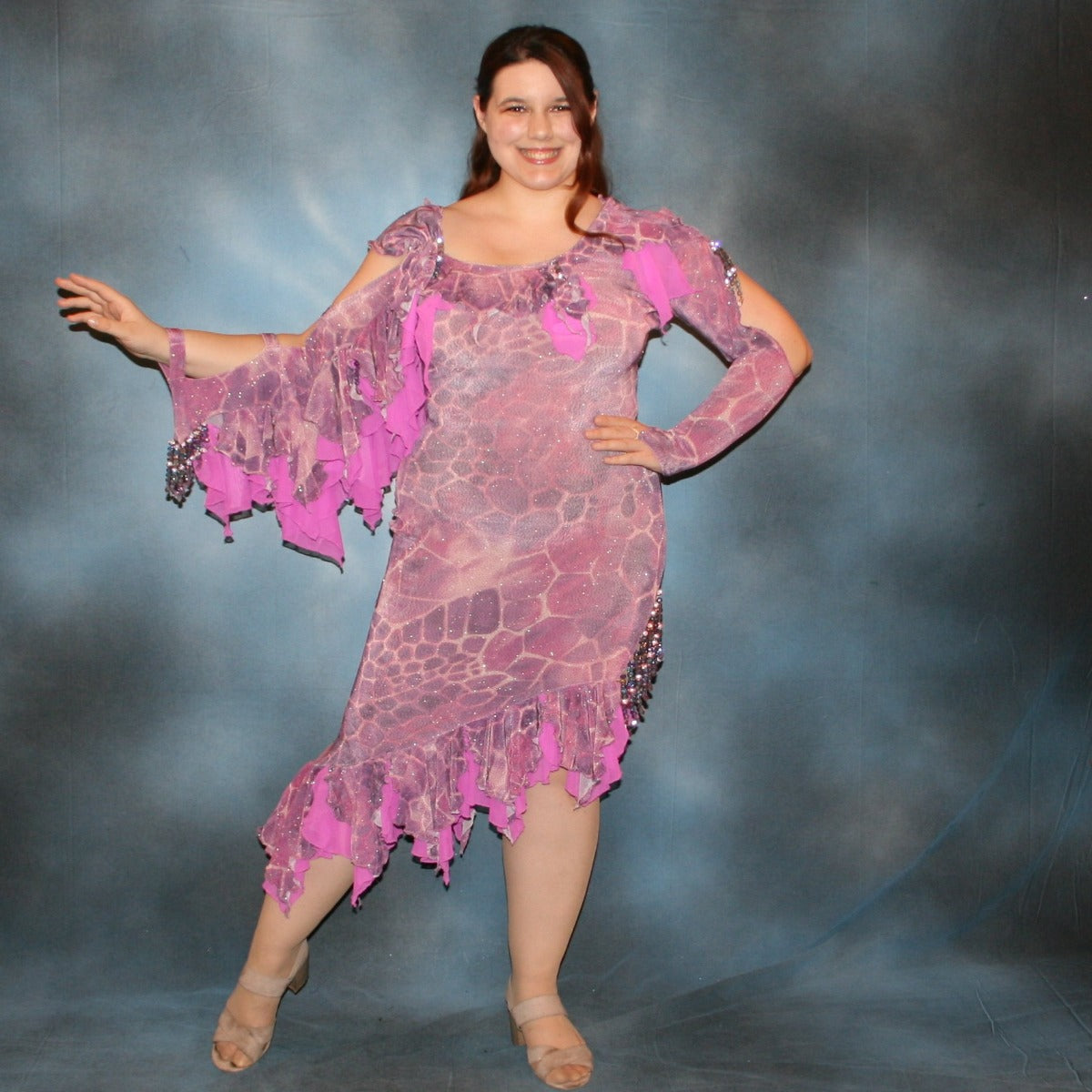 Crystal's Creations Orchid Latin/rhythm dress created of wild orchid & violet printed glitter slinky has orchid accents, flounces on one arm & skirt, embellished with Swarovski hand beading of various shades of orchid & shapes through out, is a fun & colorful Latin/rhythm dress